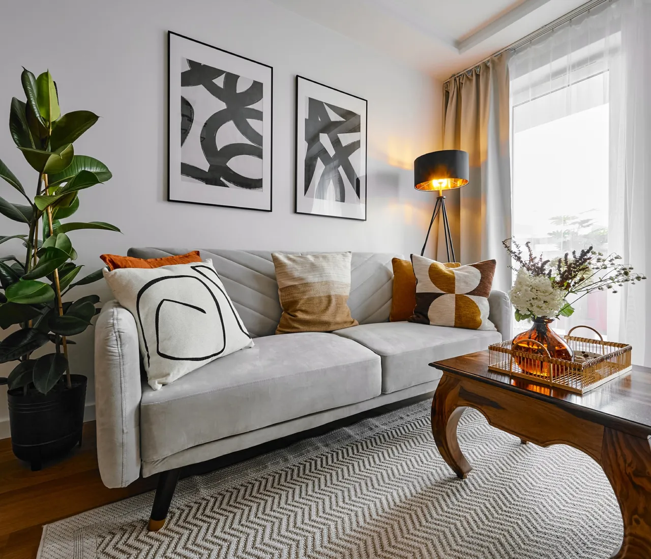 Living room with a light sofa, carved coffee table and a fig plant