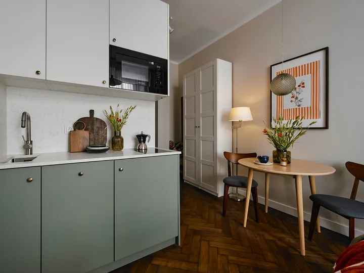 Sage-green kitchenette with a dining table