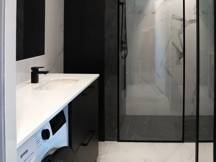 Bathroom with a walk-in shower and washing machine