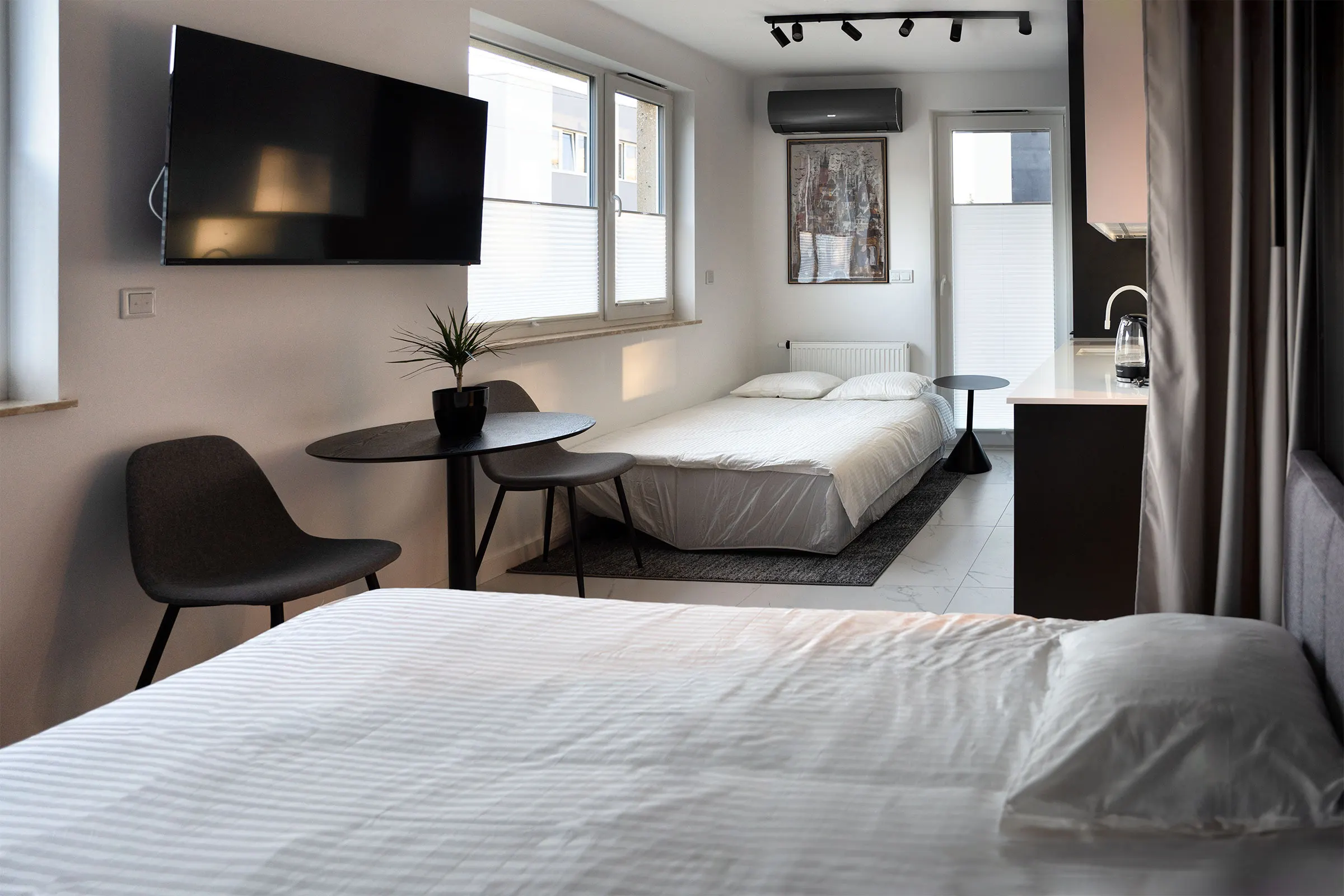 Double bed, a small table with chairs and a wall-mounted TV