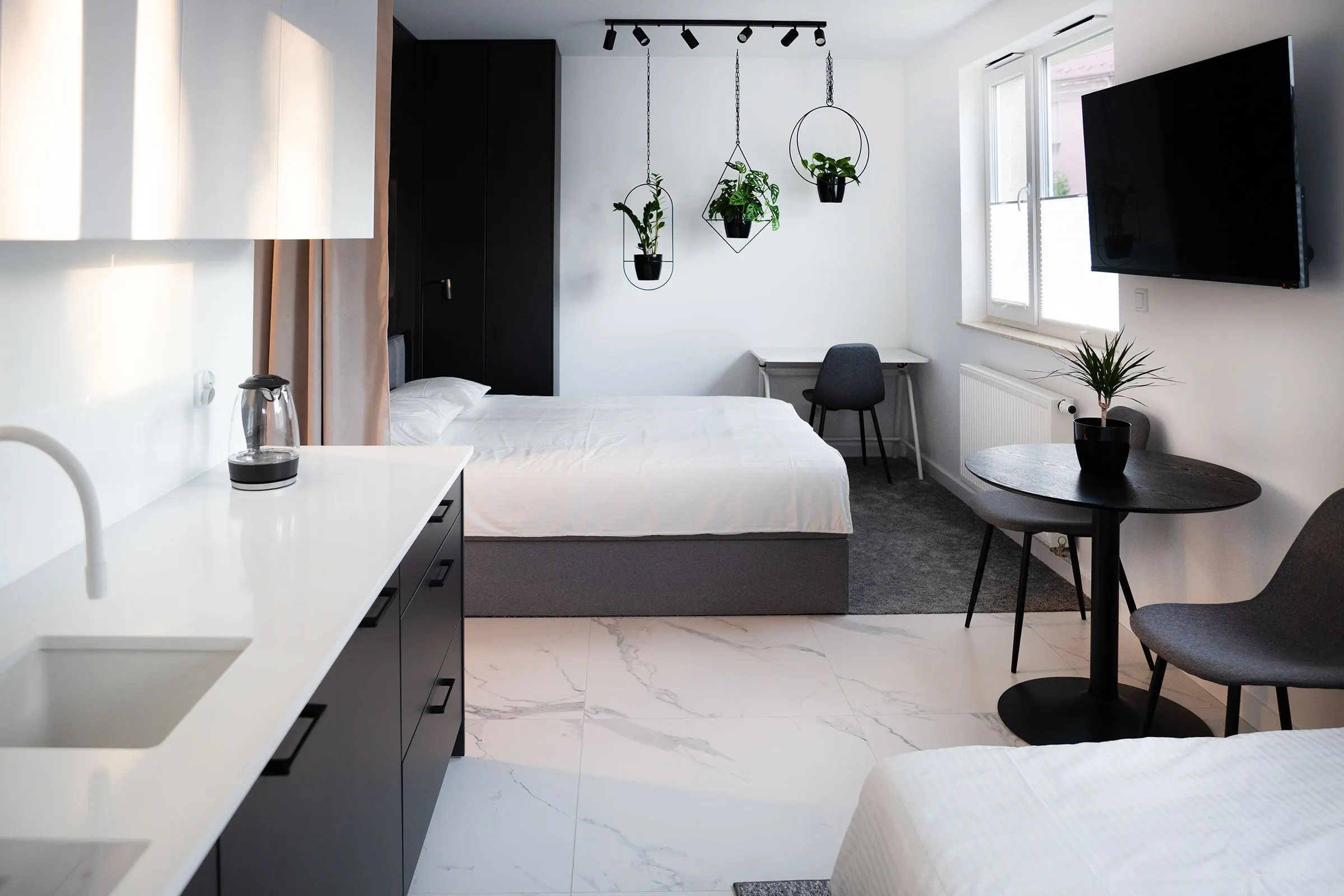 Kitchen with a white worktop, looking towards the bedroom