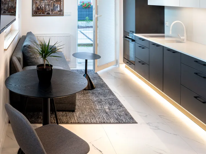 View along the apartment with the lit kitchen units