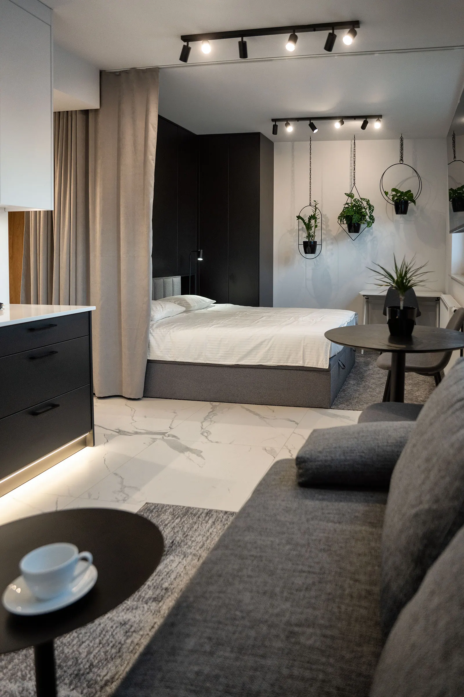 Living room with a sofa and the bed area behind a curtain